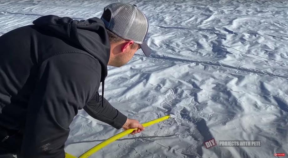 Filling the hockey rink with a hose from the well