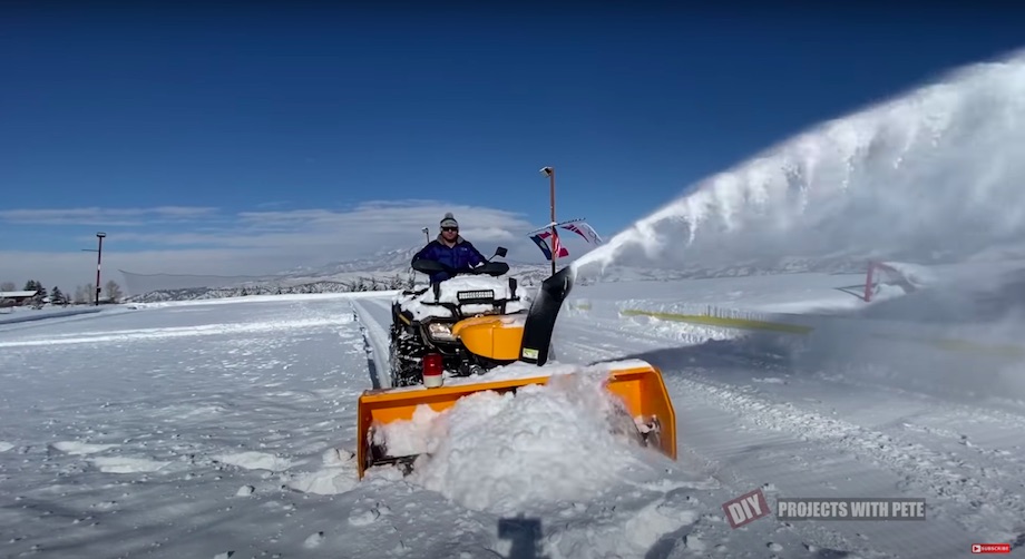 Snowblower mounted to the front of an ATV 4-wheeler